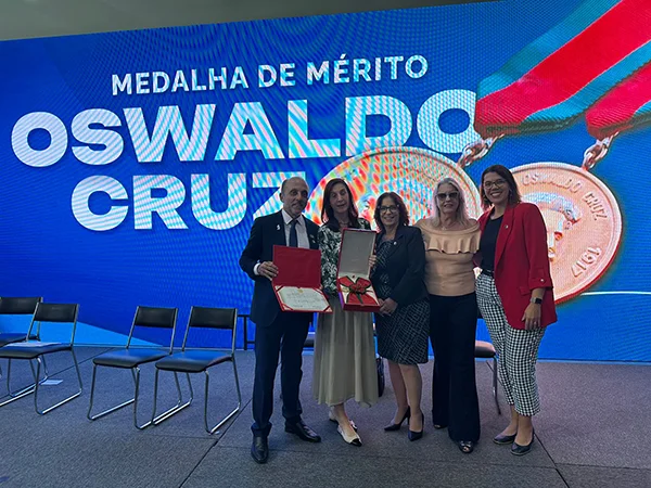 membros da diretoria da sbim posam com a medalha